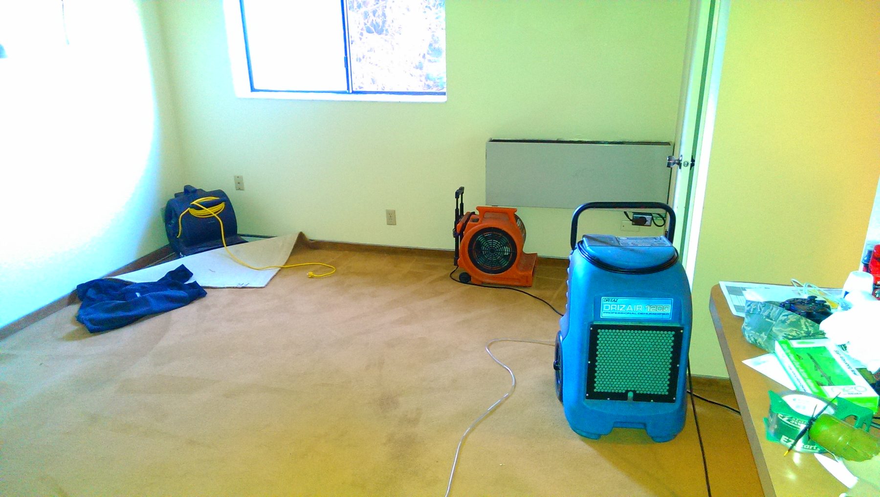 Dri-Eaz DrizAir 1200 dehumidifier and air movers on a water job